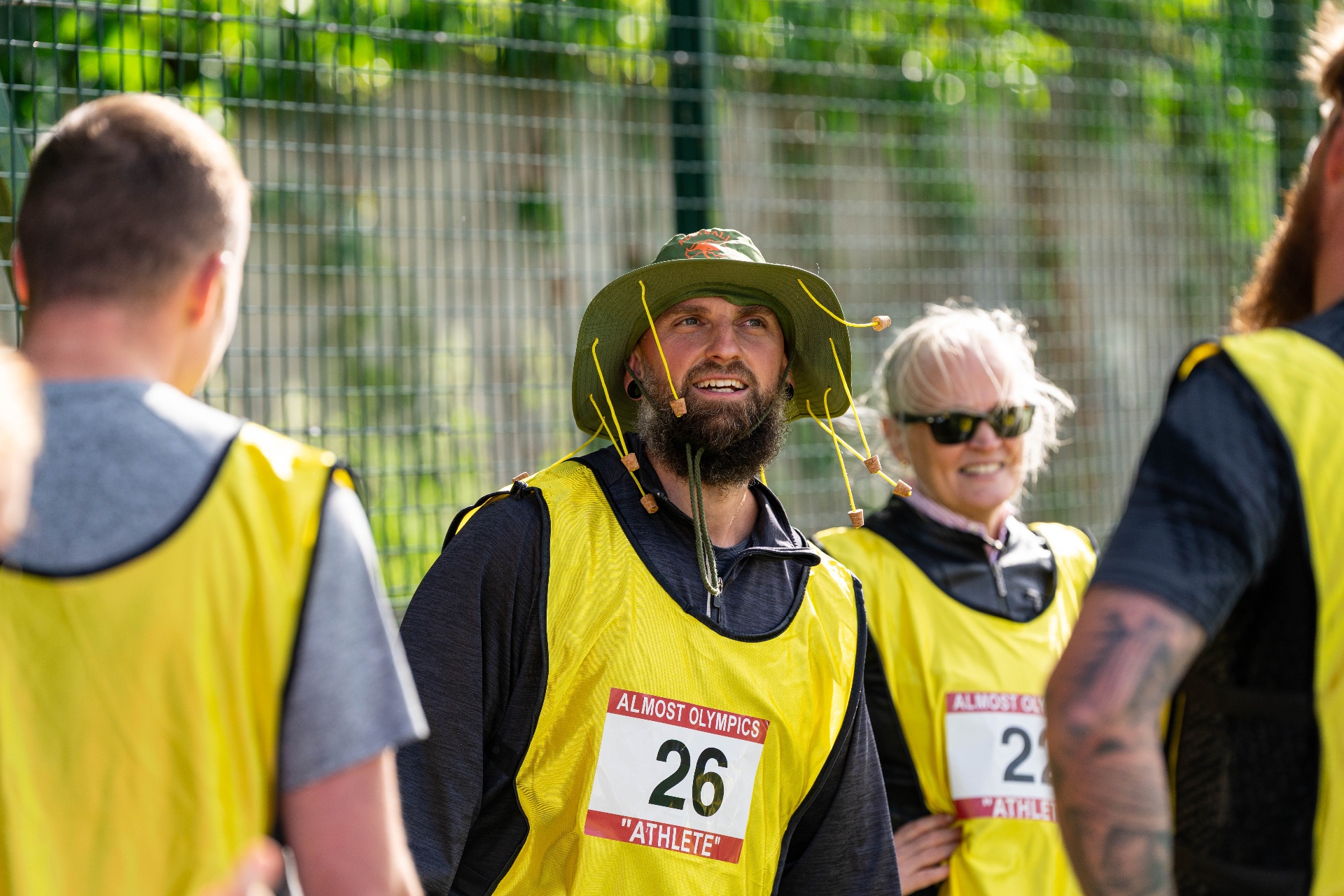 Athlete in a green hat and yellow vest at the Games of Glory opening ceremony